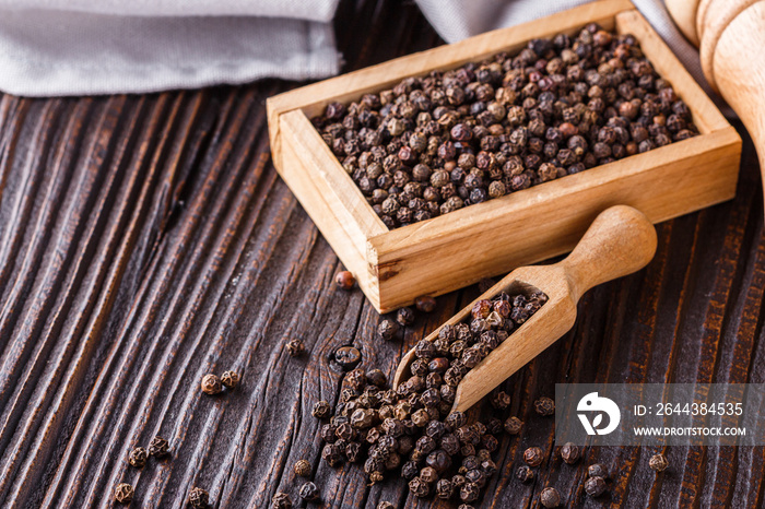 aromatic black pepper on a dark wooden rustic background