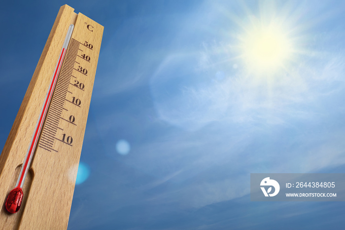 Wooden thermometer with red measuring liquid showing 40 degrees Celsius on a sunny day.