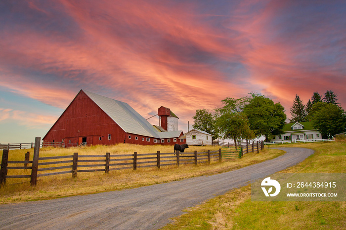 A red barn at sunrise in the fall season in the palouse wheat country in southeastern Washington.