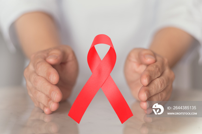 World AIDS day with red ribbon awareness symbol to support people living with HIV in December 1.