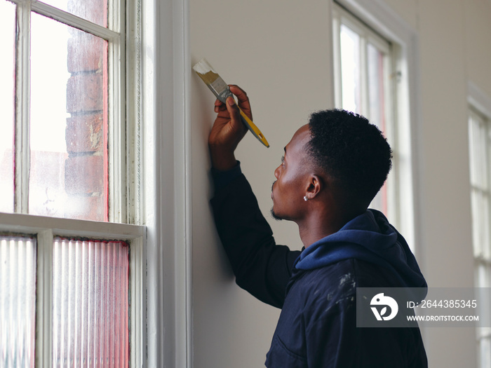 Man painting house walls white