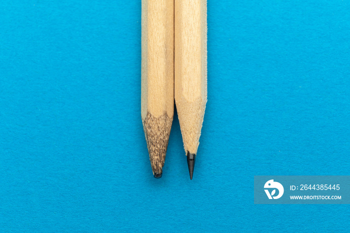 New and old pencil on a blue background.