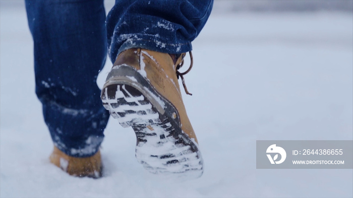 Man walking in snow. Man walking on snow, footprints in snow, behind. Man walks in the winter in the field