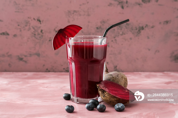 Glass of healthy smoothie with beetroots and blueberries on color background