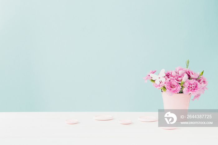 bouquet of pink Carnation flowers in vase on pink background. Empty space for text