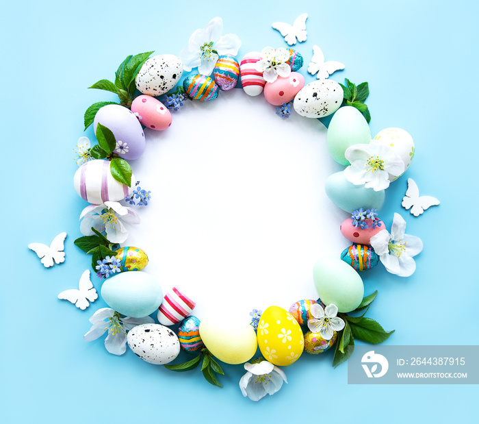 Easter eggs, colorful flowers on pastel blue background.