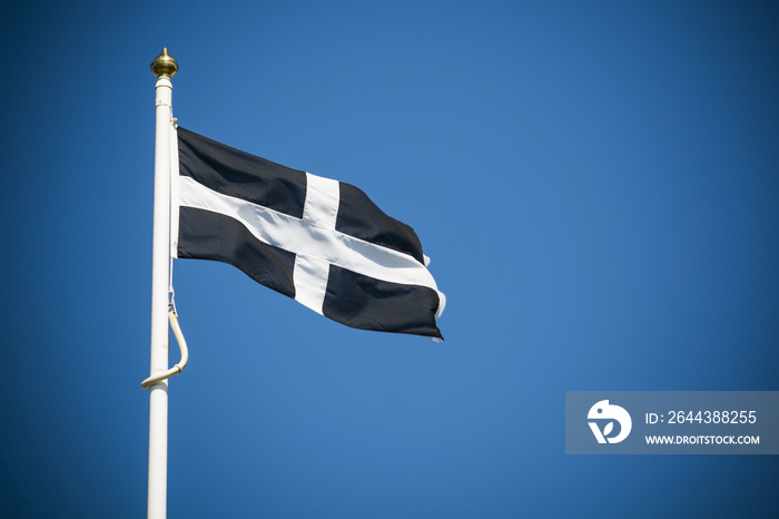 Cornwall flag flying against clear blue sky background