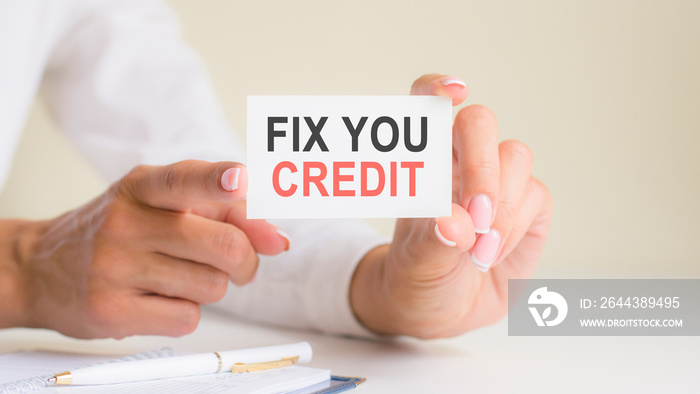 ’FIX YOU CREDIT’ card in the woman’s hands. Business, Ethics, Advertising, Marketing.