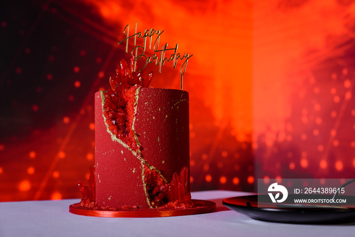 Red birthday cake with topper on a photo zone