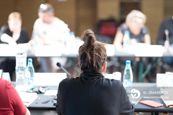 woman at the seminar and participants in the background