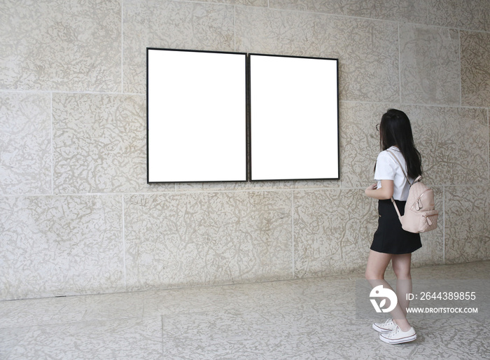 Woman in a gallery looking at empty frames