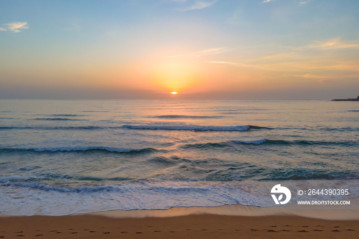 Soft haze and pastel coloured sunrise seascape