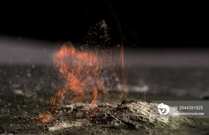 burning sand and a splash of water on a black background, the fifth element