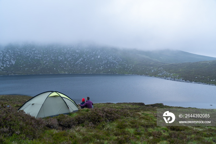 Lake landscape. Tourists camping tent.. Young charming couple in love playing .Relaxing with nature,lifestyle concept.