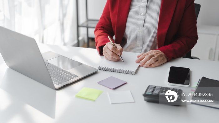 Asian elderly older female mature business woman in formal suit stock trader on stock market and money exchange rate trading working in modern office workplace.