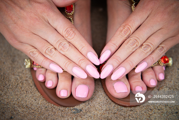 Young lady is showing her light pink manicure and pedicure nails