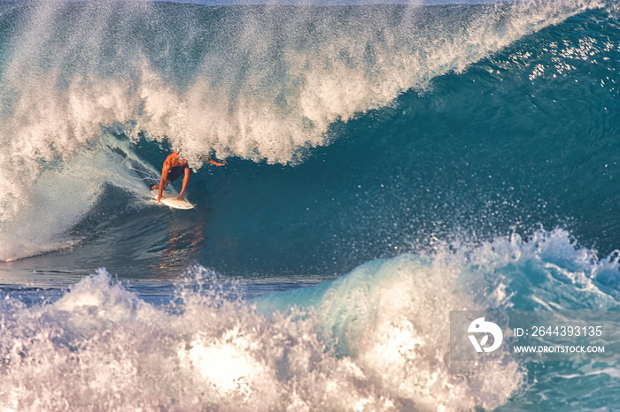 Surfing giant waves at Pipeline on the north shore of Oahu