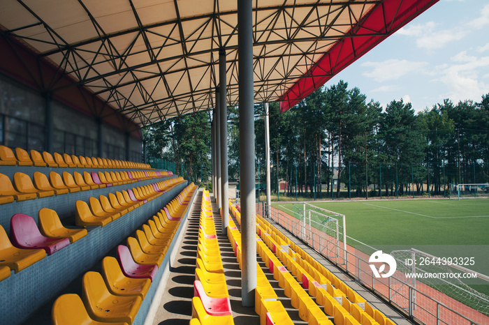 Empty stadium. Rows of yellow and red seats in stadium. Concept of empty stadium without spectators, quarantine time.