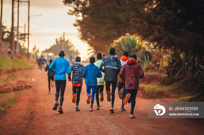 Kenyan long distance runners train in the morning on red road. Marathon training in Iten, Kenya, Home Of Champions, Eldoret. Marathon motivation, sport photo, edit space