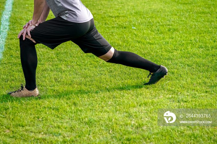 football player was stretching and warm up.