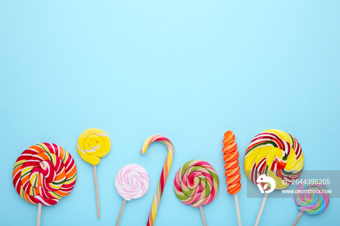 Many colorful lollipops on blue background. sweet candy concept