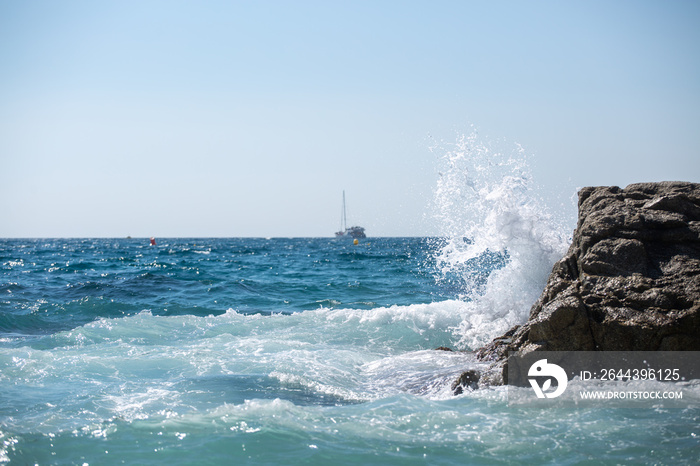 sea wave splashes over stone