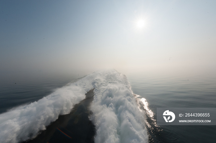 Wake of a fast catamaran passenger ferry on a sunny day with calm seas.