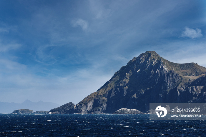 steep cliffs and sea at Cape Horn against blue sky