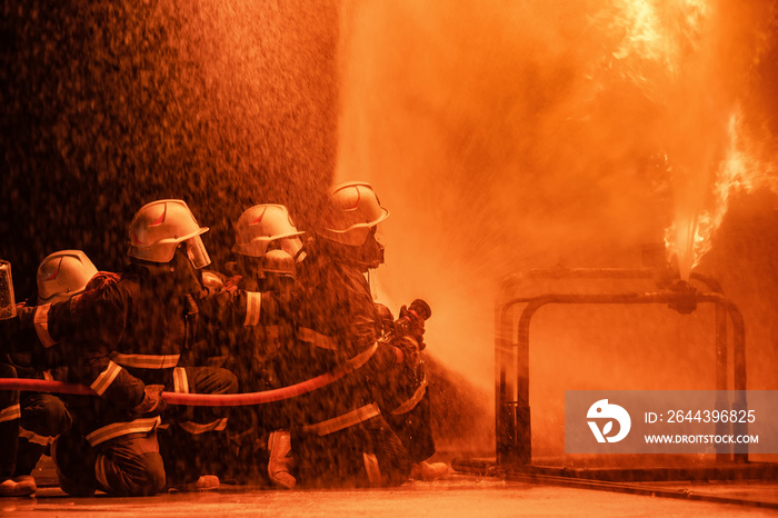 Firefighter using extinguisher or Twirl water fog type fire extinguisher to spray water from hose for fire fighting with fire flame on fuel and control fire for safety in plant of industrial area.