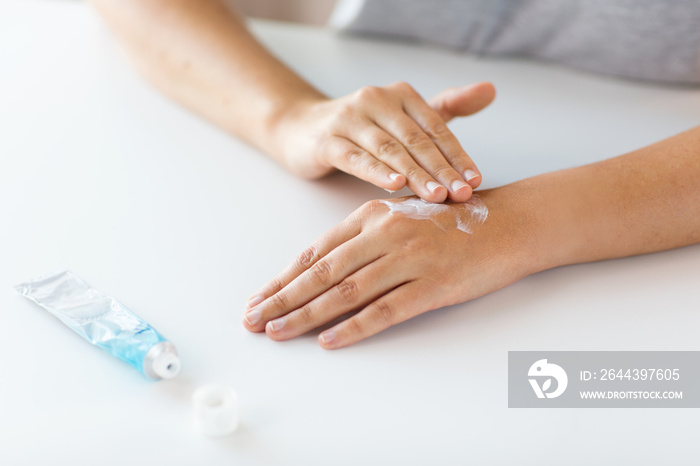 close up of hands with cream or therapeutic salve