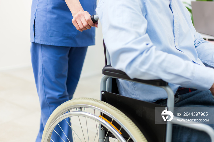 Female doctor helping a patient on a wheelchair