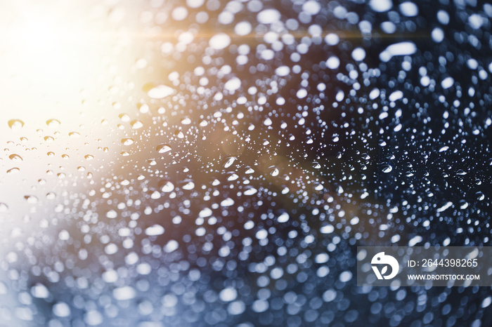 after rain water drops on glass with sun light background.