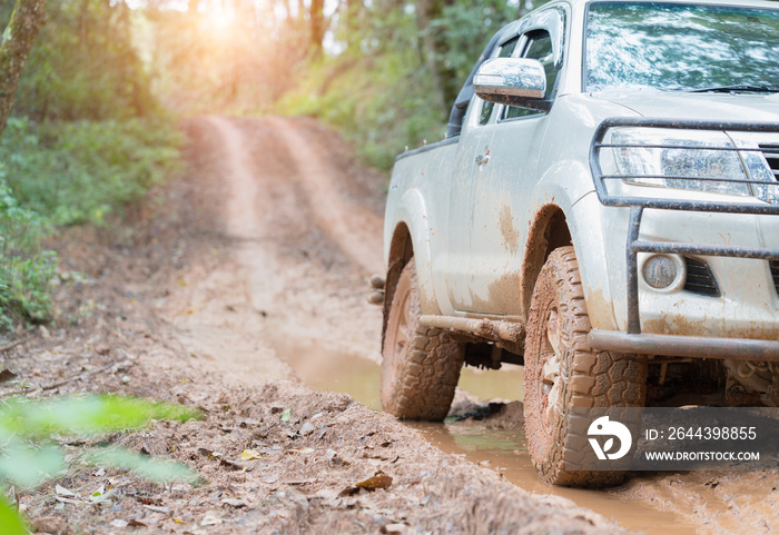 Dirty offroad car, SUV covered with mud on countryside road, Off-road tires,  offroad travel  and driving concept.