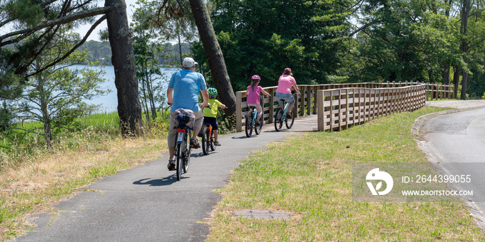 tourist family on bike ride in Lacanau lake bridge