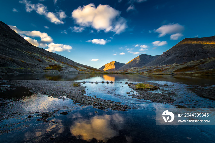 Russia. Murmansk region. Mountains of the Khibiny. Apatity. The city of Kirovsk. Reflection of the sky and mountains in the water.