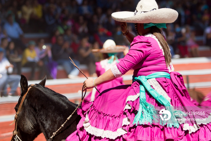 A mexican escaramuza girl salutes the audience before beginning the performance of charreada