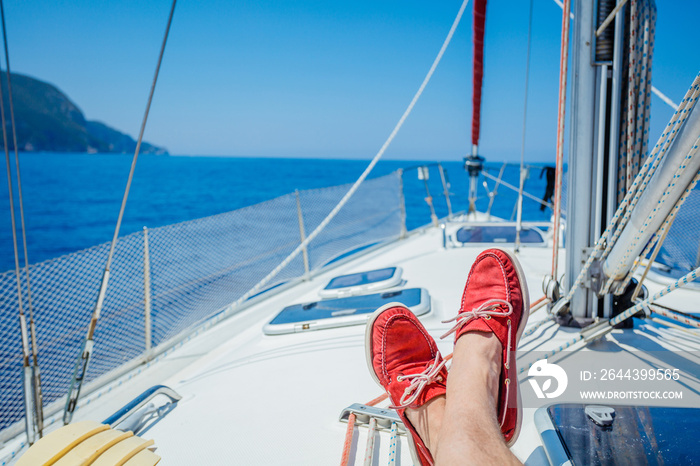 A pair of man legs in topsiders on white yacht deck. Yachting