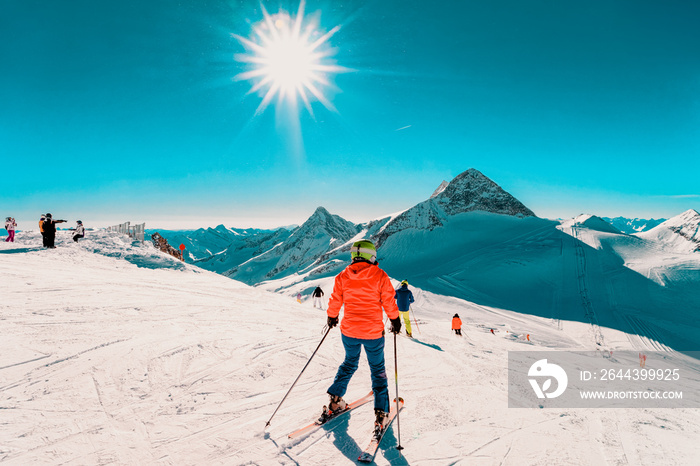 Woman Skier skiing at Hintertux Glacier in Tyrol in Mayrhofen in Austria, winter Alps. Lady girl Ski at Hintertuxer Gletscher in Alpine mountains with white snow and blue sky. Sun shining.