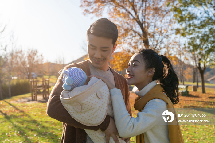 年轻夫妻抱着宝宝散步