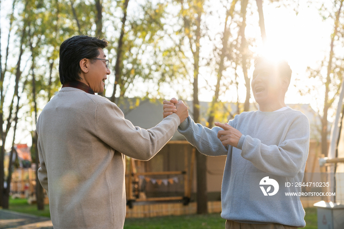 两个中老年男人开心地握手