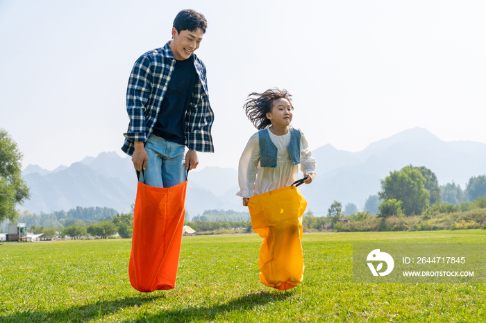 爸爸和女儿在草地上做游戏