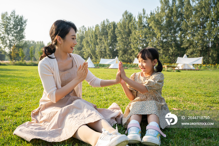 妈妈和女儿在草地上做游戏