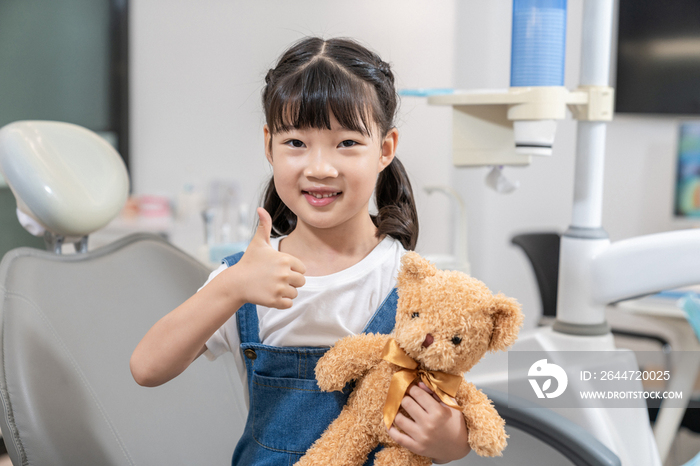 小女孩在牙科诊所拿着泰迪熊