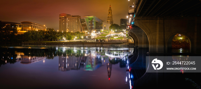 Hartford downtown night cityscape and Founder’s bridge reflected on Connecticut River. Brilliant city lights illuminating the dark sky and purple river water.