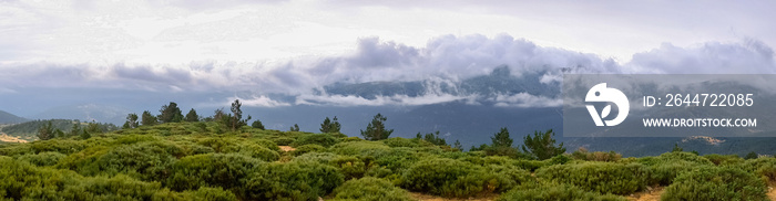 Panoramic image of the views of the Sierra de Guadarrama with its clouds from the top of a mountain peak.