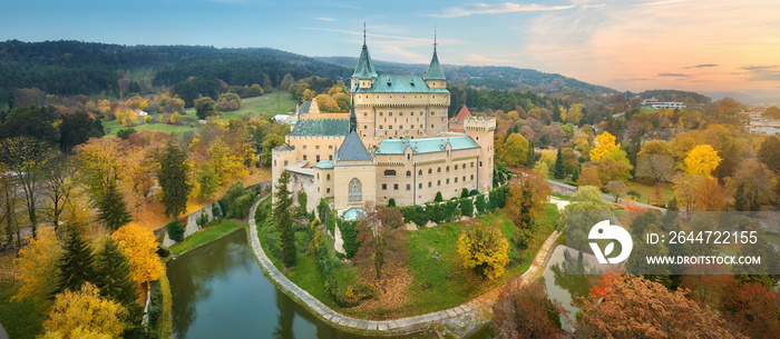 Bojnice castle. Panoramic aerial view of a neo-gothic romantic fairy-tale castle in a colourful autumn garden. Fortification, towers and water moat. UNESCO  travel concept of the castle and chateau.