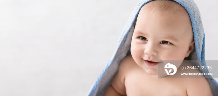 Cute little baby boy in hooded towel after bath