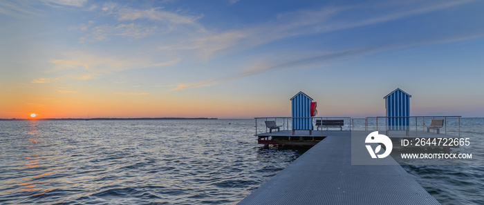 Panorama view of sea with pier on sea against cloudy sky during sunset. Pier in the municipality of Stein (Baltic Sea), Probstei, Schleswig-Holstein, Germany.