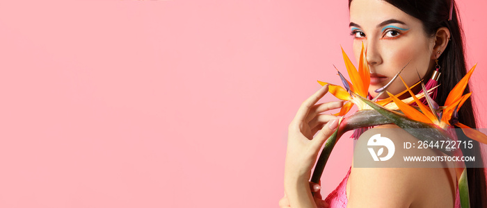 Pretty young woman holding strelitzia flowers on pink background with space for text