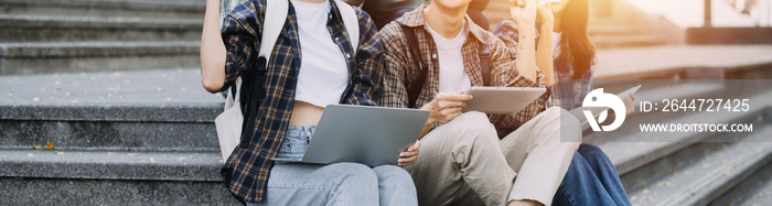 Young adult happy smiling Hispanic Asian student wearing headphones talking on online chat meeting using laptop in university campus or at virtual office. College female student learning remotely.